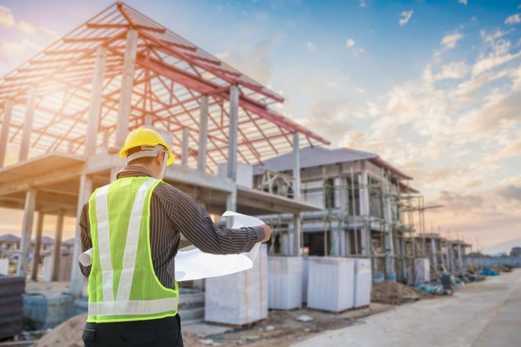 Construction worker reviewing blueprints outdoors