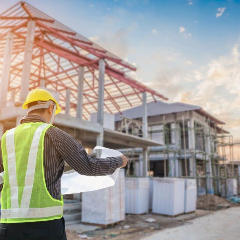 Construction worker reviewing blueprints outdoors