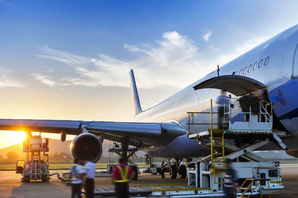 Airplane being serviced at sunset.