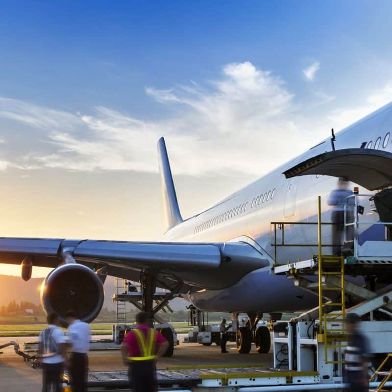 Airplane being serviced at sunset.
