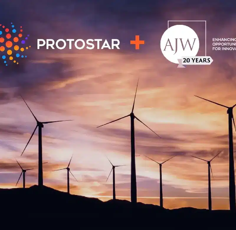 Wind turbines at dusk with Protostar and AJW logos